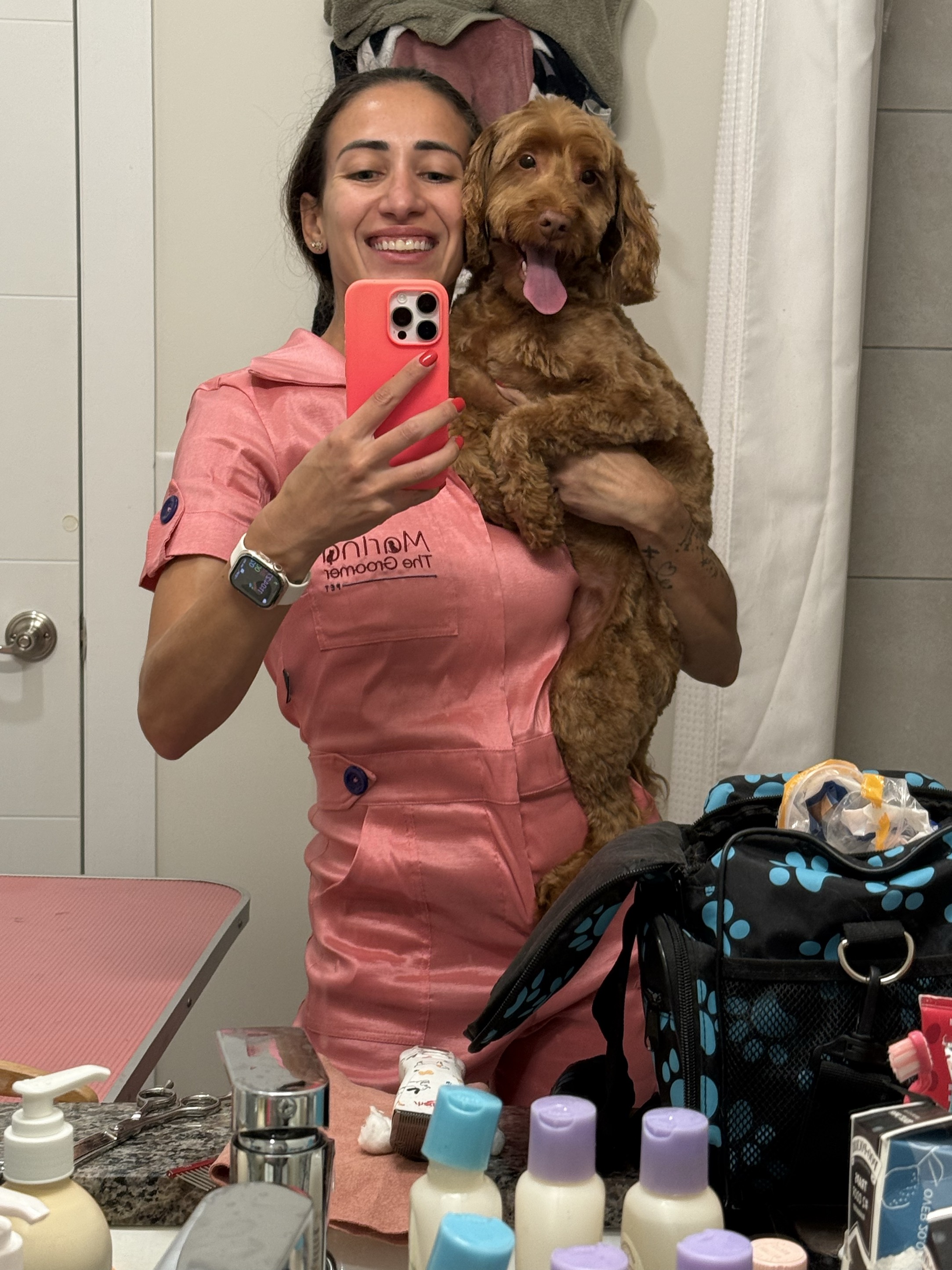 Marina, professional pet groomer, holding a happy labradoodle